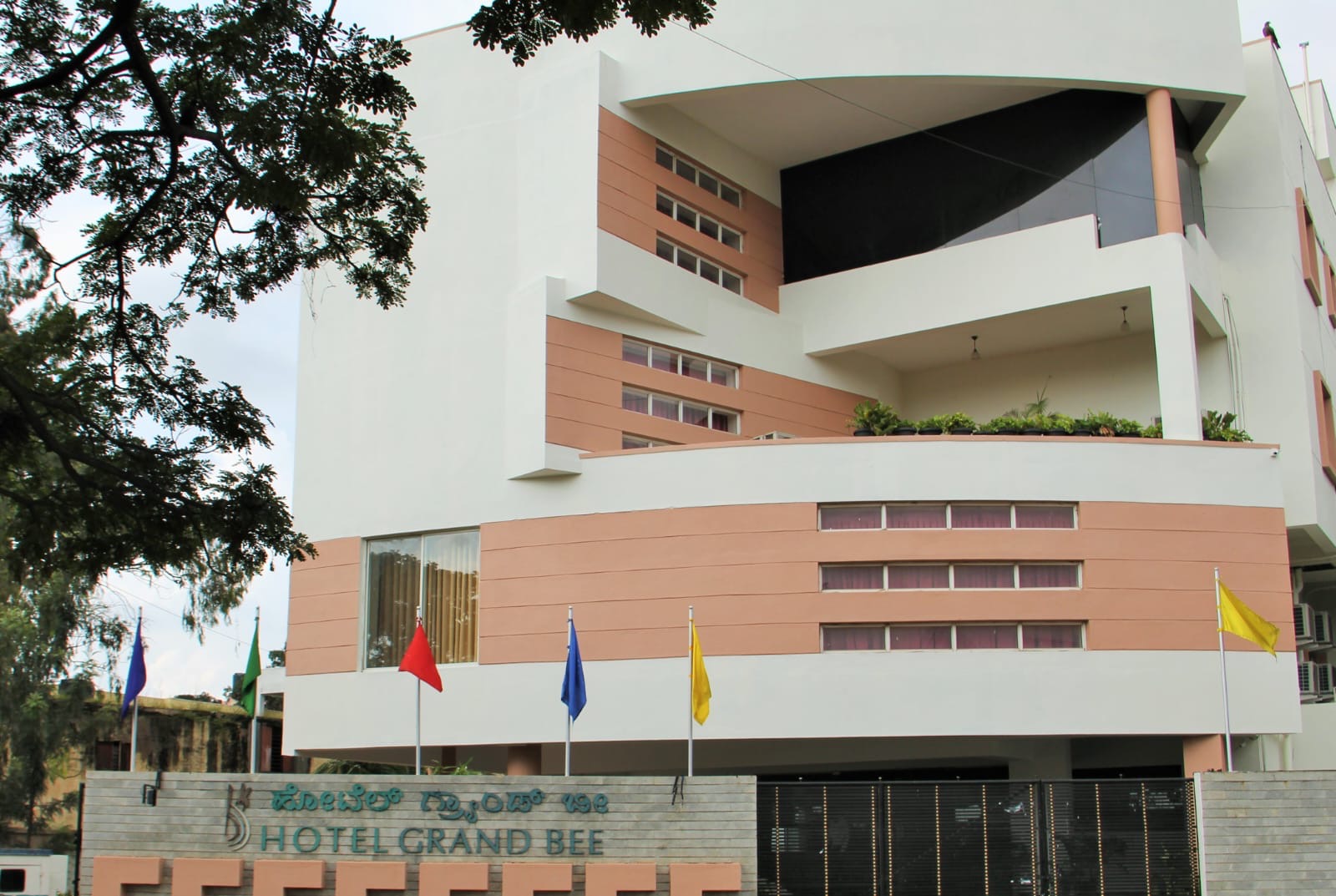 Hotel Grand Bee — exterior with signage and flags